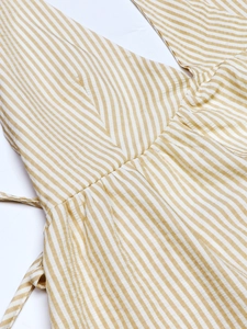 Detail of yellow and white striped V-neck top with waist drawstring and pleated texture