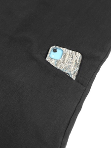 Detail shot of the deep side pocket on black linen dress showing its practical storage space