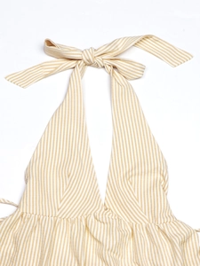 Close-up of halter neck design with yellow stripes and bow tie detail on soft fabric
