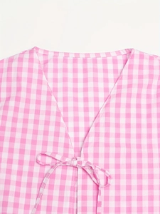 Détail du haut à carreaux roses avec col en V et fermeture à nouer en coton et lin