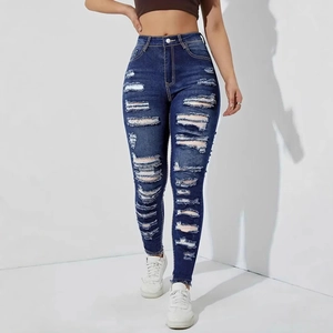 Detail of high waist distressed skinny jeans with ripped holes and frayed hems
