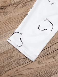 Nahaufnahme der weißen Polo-Manschette mit abstrakten schwarzen Linien und feinen Nähten