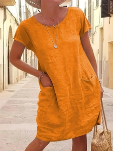 Detail of orange cotton linen dress with side pockets and textured fabric weave