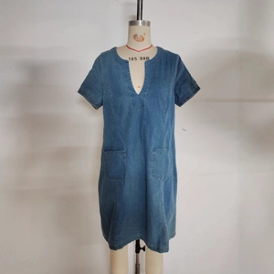 Detailed view of women's blue denim midi dress featuring a V-neckline and front utility pockets