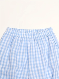 Détail d'un pantalon en coton à carreaux bleu et blanc avec taille élastique souple