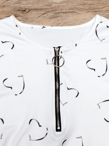Detail eines Polo-Shirts mit Reißverschluss, Metallring und Herzmuster-Druck