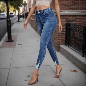 Close-up of distressed hem detail on high waisted skinny blue denim jeans for women