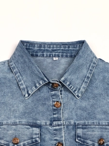 Detail of blue denim dress featuring classic collar buttons and front flap pockets