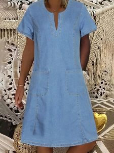 Detail of V-neckline and front square pockets on light blue denim summer dress