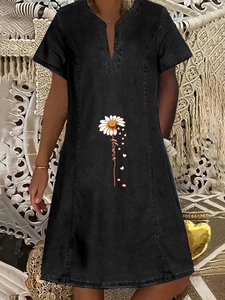 Detailweergave van madeliefje en flower tekstprint op grijze denim jurk met V-hals
