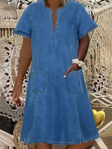 Detail view of denim V-neck dress featuring short sleeves and two functional front pockets