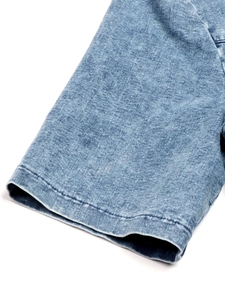 Detailed close-up of denim dress sleeve with double-stitched hem and washed texture