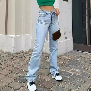 Outdoor street view of light blue high waist straight leg denim jeans with green top