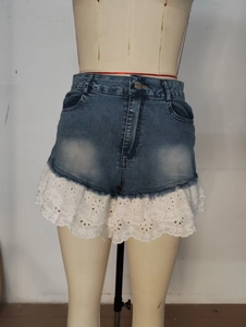 Détail d'un short en jean bleu foncé avec dentelle blanche et bordure à volants