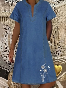 Dettaglio dell'abito in denim a maniche corte con scollo a V e stampe floreali di soffione