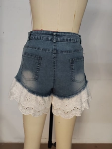 Détail du short en jean avec patchwork de dentelle blanche et poches arrière