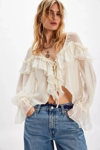 Detail of ruffled V-neck and tiered flounce sleeves on a beige chiffon blouse