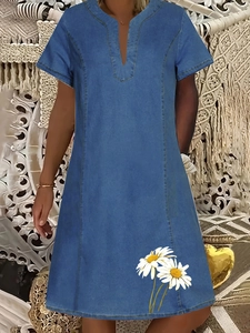 Dettaglio di un vestito in denim a maniche corte con scollo a V e stampa floreale a margherita