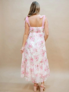 Back view of a long floral sundress with pink lace straps and layered ruffle hemline