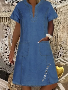 Detail of short sleeve V-neck denim dress with white daisy embroidery and front pockets