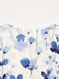 Close-up detail of round neckline with blue watercolor floral prints on white fabric