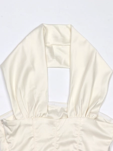 Detail of cream satin halter top featuring gathered pleats and invisible side zipper