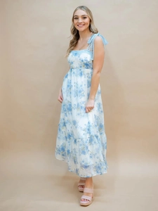 Detail of blue floral maxi dress with lace bow straps and tiered ruffled hemline