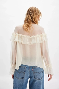 Detail of ruffled chiffon blouse back and blue denim jeans with classic pocket stitching