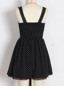 Polka dot backless summer dress with lace straps and flared hem on a mannequin
