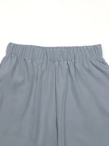 Close-up of the elastic waistband and smooth fabric on light blue floral trousers