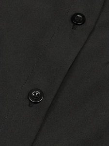 Gros plan du haut sans manches noir en coton montrant les coutures et les boutons
