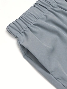 Detail of the elastic waistband and side pockets on grey floral print casual trousers