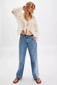 White chiffon blouse with ruffle trim and straight leg jeans with side panels