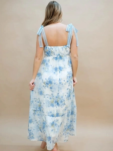 Detail of floral maxi dress showing blue crochet lace straps and elegant bow tie back