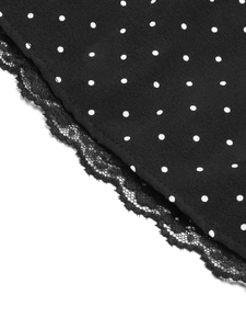 Detailed view of black polka dot fabric with delicate lace trim and quality stitching