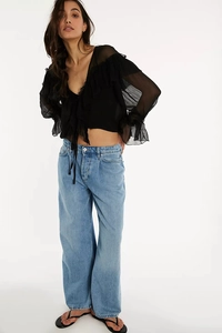 Detail of black chiffon crop top featuring elegant layered ruffles and sheer fabric texture