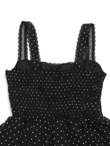 Detailed view of smocked bodice and lace straps on a black polka dot summer dress