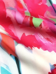 Macro detail showing vibrant floral print on premium twill fabric with silky texture