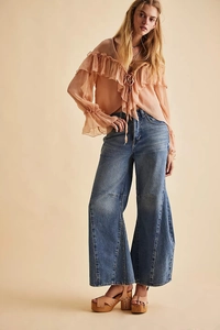 Detail of sheer pink chiffon top with ruffled edges and elegant front tie-up design