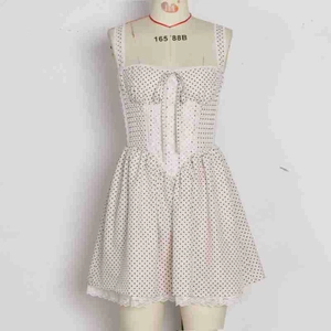 Close-up of white polka dot dress featuring a corset waist and delicate lace hem detail