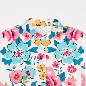 Detail of floral printed blouse showing stand collar and white round buttons closely