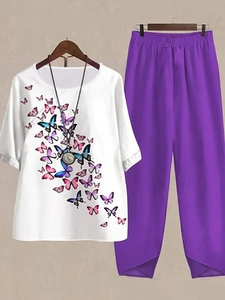 Close-up of women's round neck white top with butterfly print and purple loose trousers