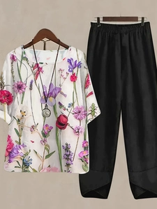 Detail of floral print linen top and wide-leg black trousers set for women