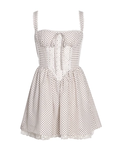 Close-up of white polka dot dress featuring lace trim edges and a small bow detail