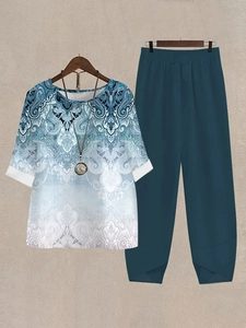 Detail of bohemian floral print top and navy wide leg pants with unique hem design