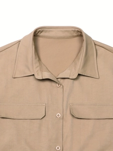 Detail of khaki safari shirt featuring buttoned pockets and classic turndown collar