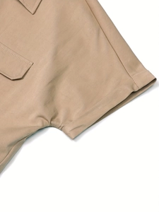 Detail of khaki safari shirt featuring chest flap pocket and rolled short sleeve cuff