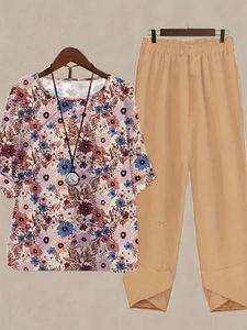 Detail of floral round neck top and casual khaki pants with unique overlapping hem design