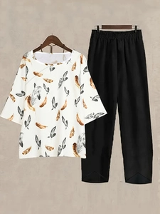 Close-up of women's two-piece set with floral print top and black wide-leg trousers