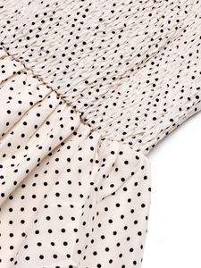 Detail of smocked elastic fabric with black polka dots on a summer backless dress